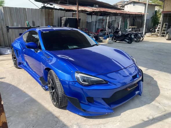 ด้านหน้ารถสปอร์ตสีน้ำเงินพร้อมชุดแต่งสีดำ